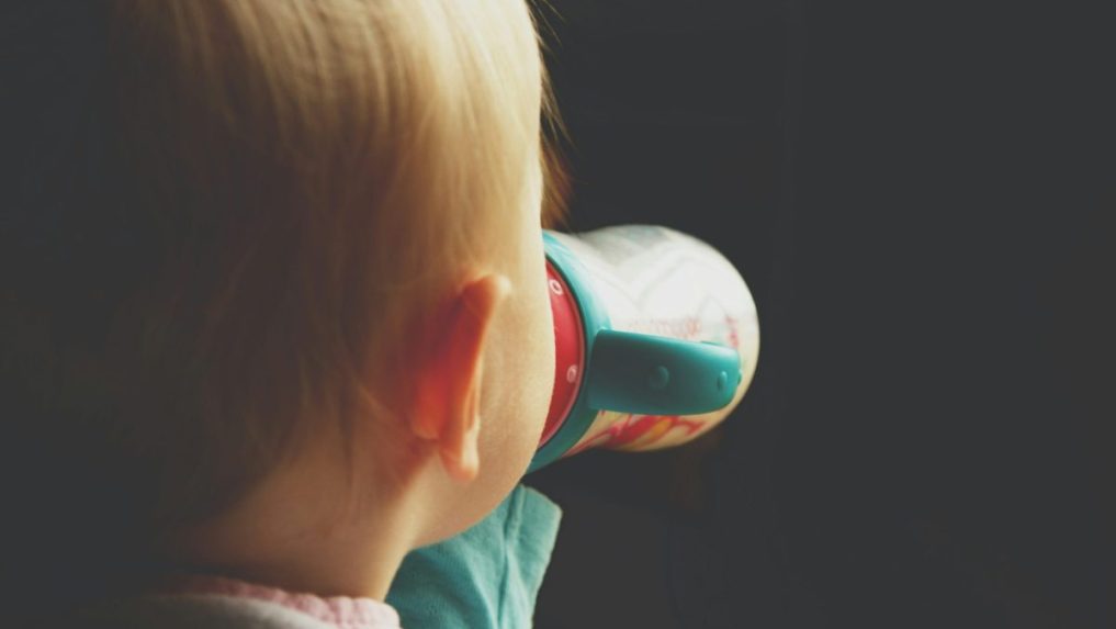 Na snímke dieťa pije mlieko z fľaše.