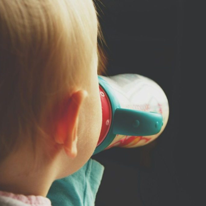 Na snímke dieťa pije mlieko z fľaše.