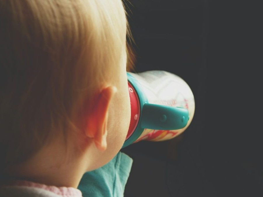 Na snímke dieťa pije mlieko z fľaše.