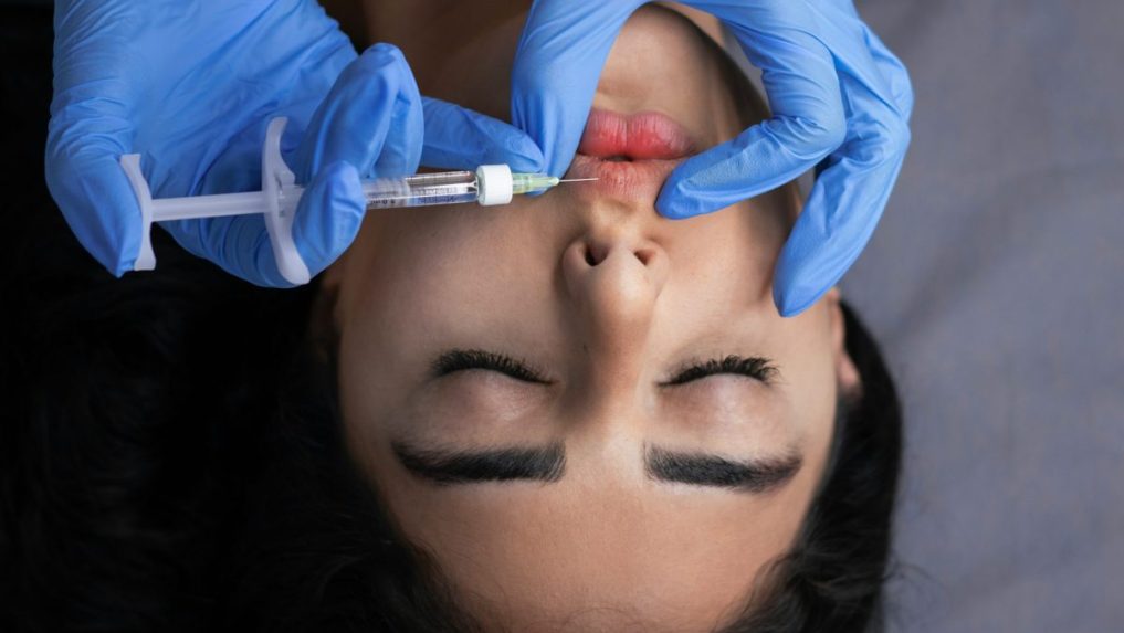 Na snímke pichá lekár žene do pier ihlu.