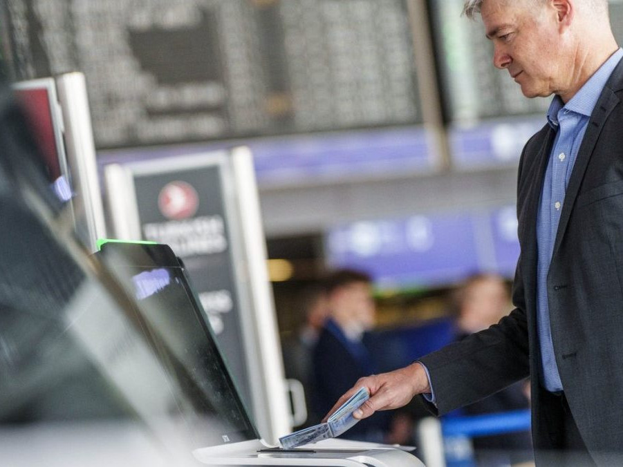 Muž skenuje na letisku svoj pas.
