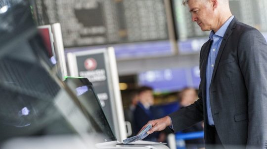 Muž skenuje na letisku svoj pas.