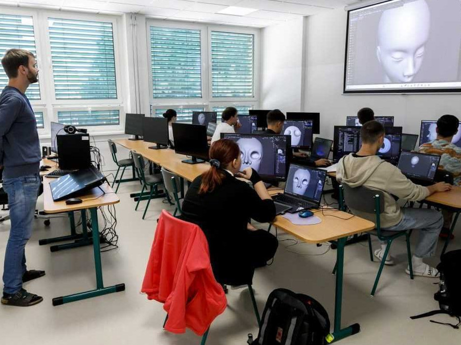 Na ilustračnej snímke učiteľ a študenti v triede.