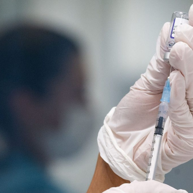 Žena naťahuje z ampulky do injekčnej striekačky vakcínu proti ochoreniu COVID-19.