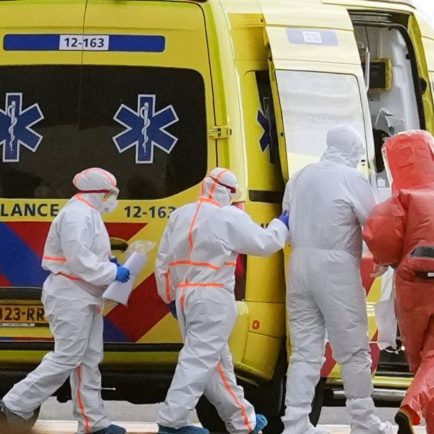 Na snímke zdravotnícky personál pomáha pacientovi nasadnúť do sanitky.