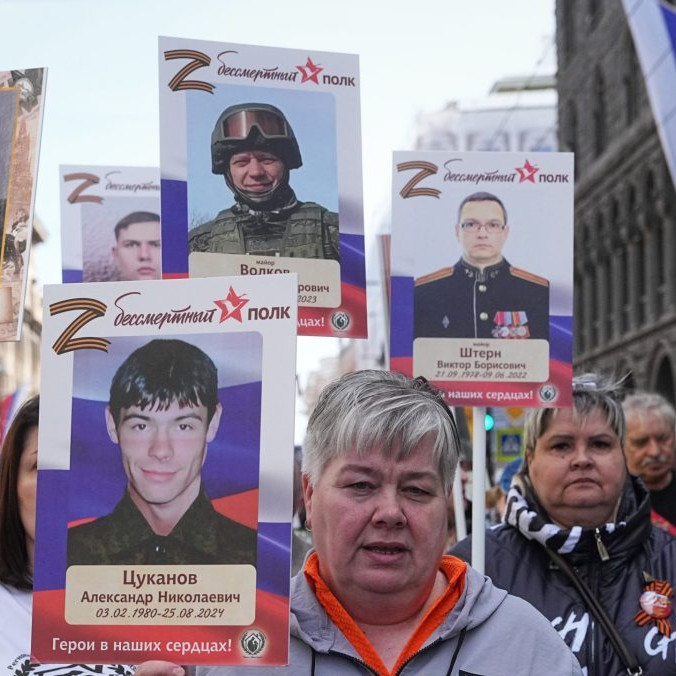 Ľudia v ruskom Petrohrade kráčajú s fotografiami blízkych, ktorí padli vo vojne na Ukrajine.