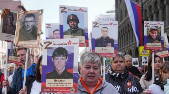 Ľudia v ruskom Petrohrade kráčajú s fotografiami blízkych, ktorí padli vo vojne na Ukrajine.