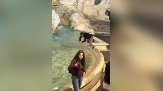 Turista skáče do fontány di Trevi.
