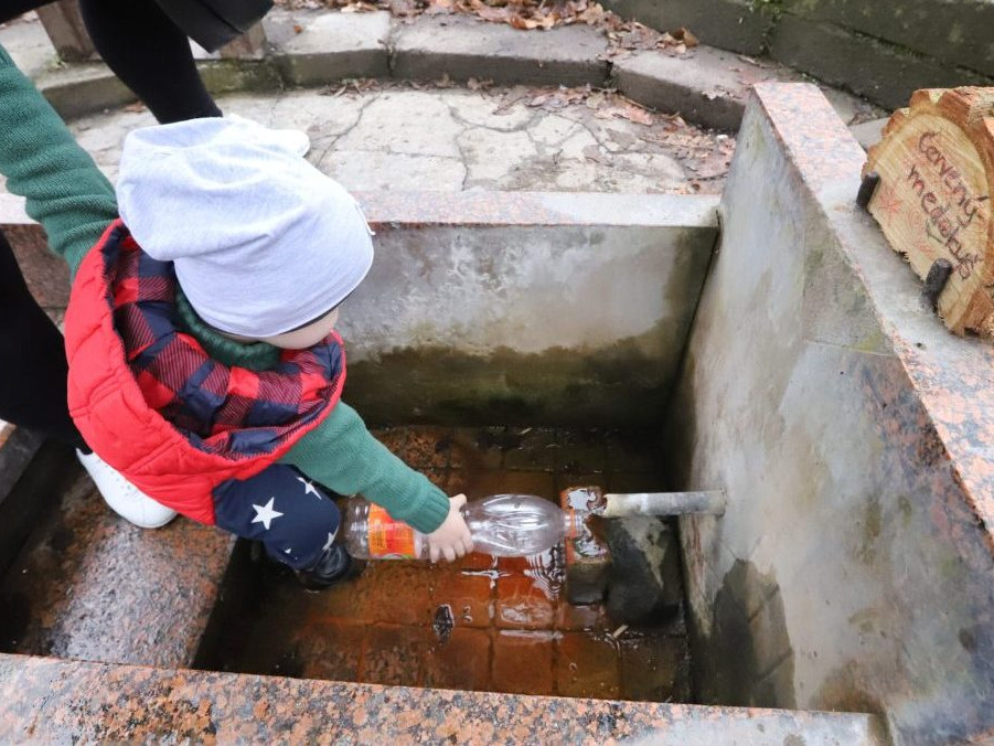 Ľudia si čerpajú vodu z prameňa Červený medokýš.