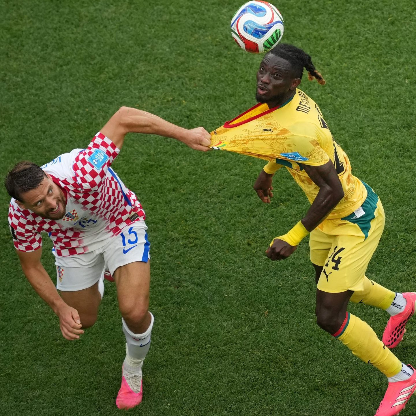 Chorvát Nikola Vlasic drží za dres Ghančana Gideona Mensaha.