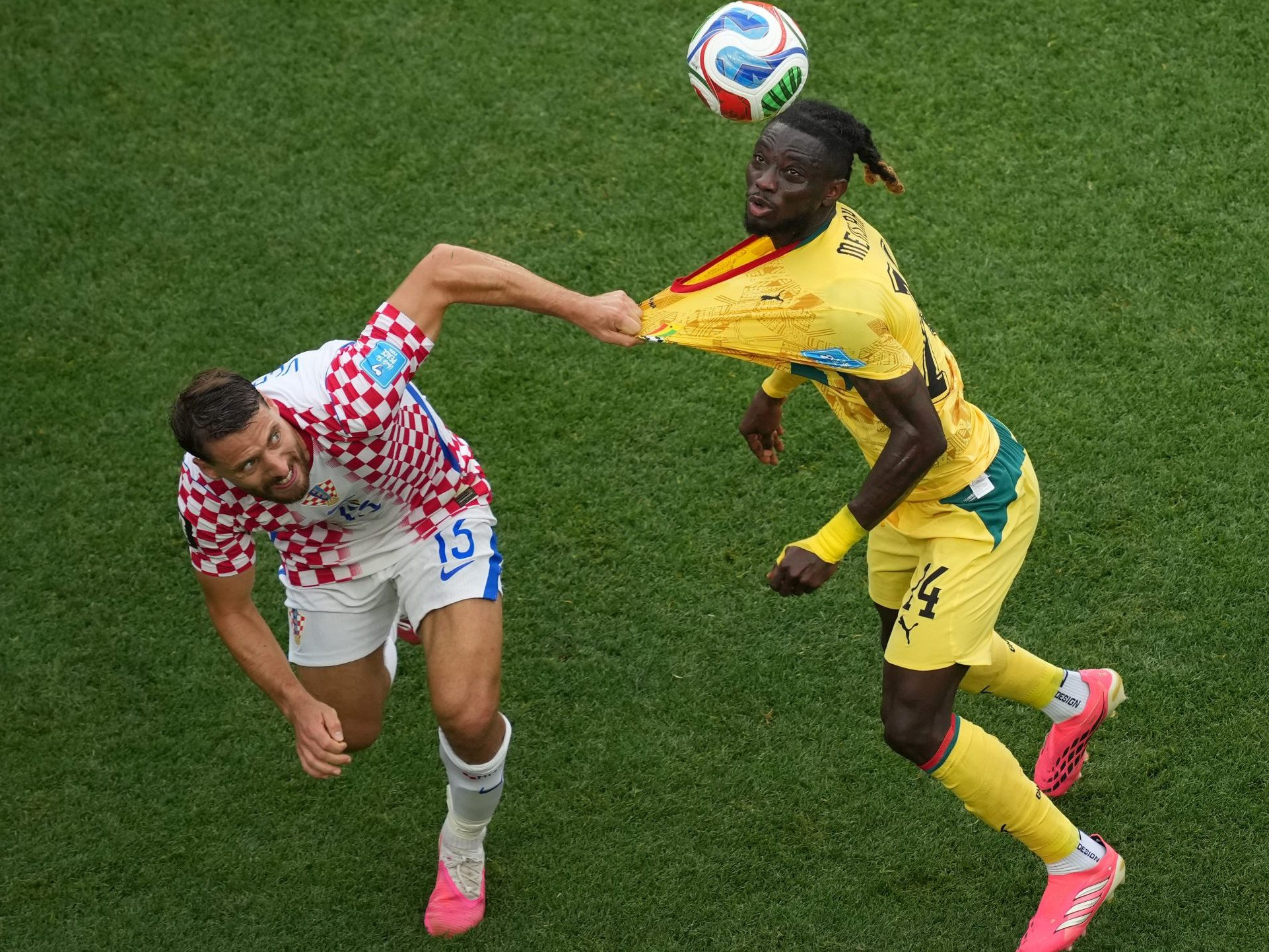 Chorvát Nikola Vlasic drží za dres Ghančana Gideona Mensaha.