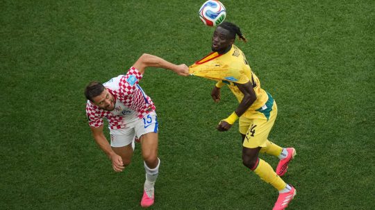 Chorvát Nikola Vlasic drží za dres Ghančana Gideona Mensaha.