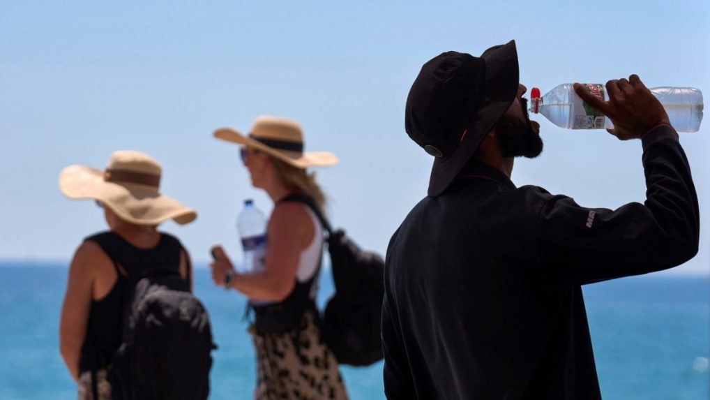 Turista sa osviežuje počas horúceho dňa v Barcelone.