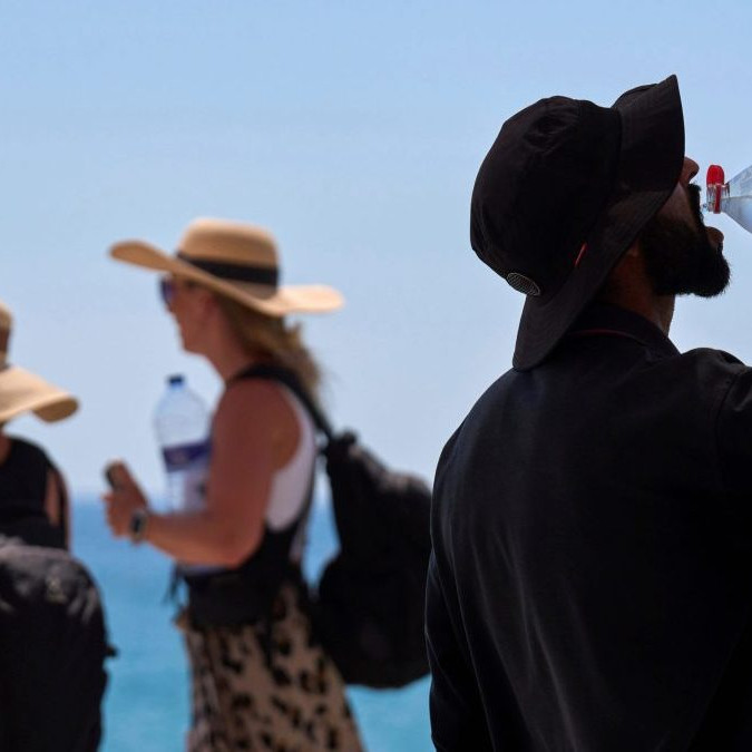 Turista sa osviežuje počas horúceho dňa v Barcelone.