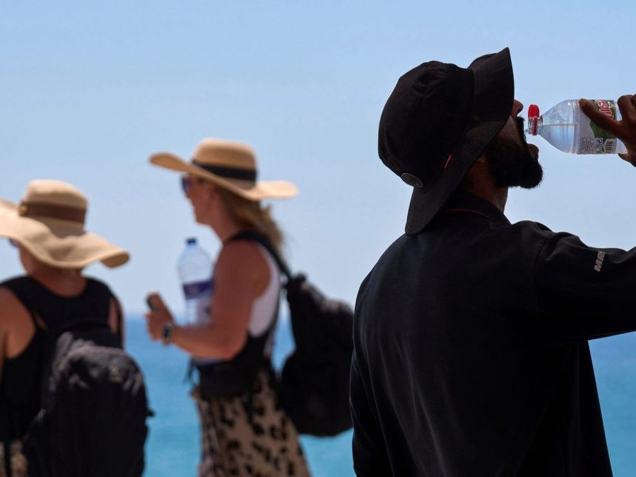 Turista sa osviežuje počas horúceho dňa v Barcelone.