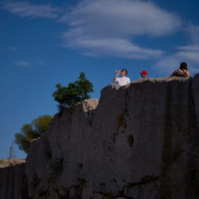 Turista pije fľaškovú vodu v Grécku.