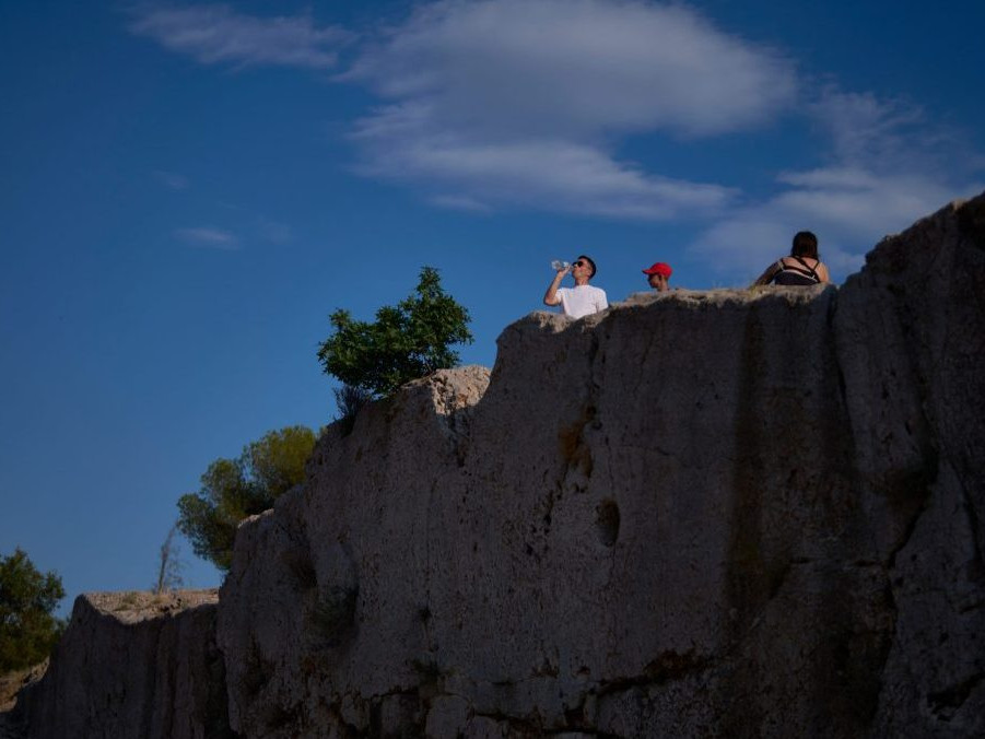 Turista pije fľaškovú vodu v Grécku.