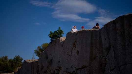Turista pije fľaškovú vodu v Grécku.