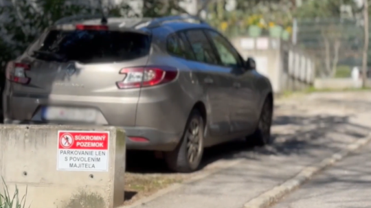Na snímke zaparkované auto pri tabuli "súkromný pozemok".