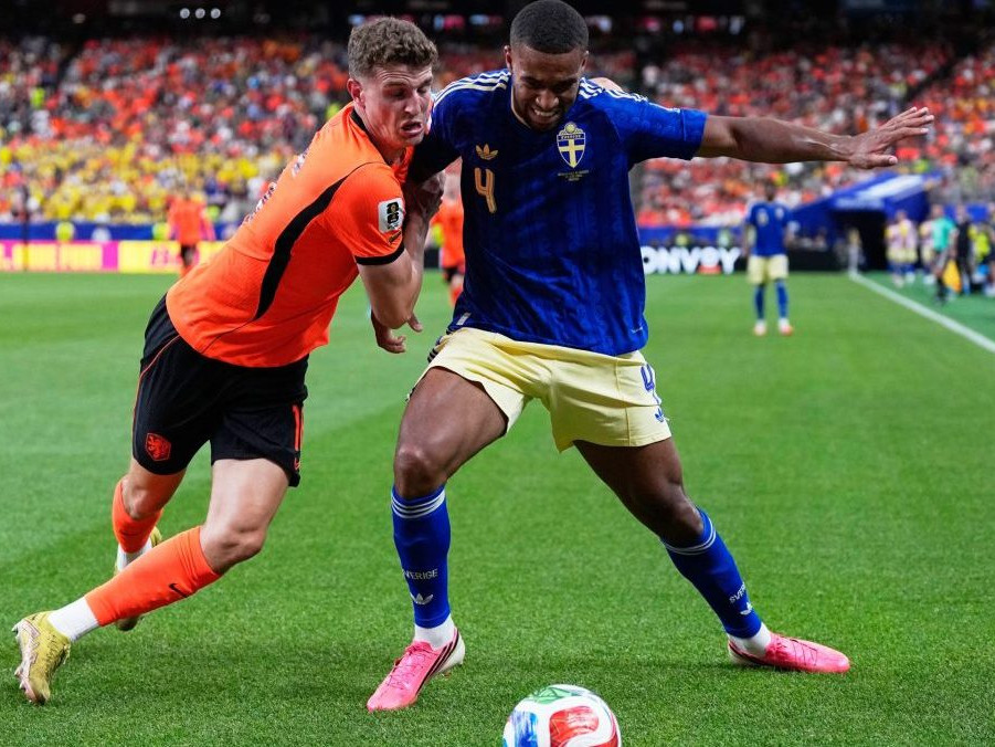 Holanďan Guus Til bojuje o loptu so švédskym futbalistom Isakom Hienom.