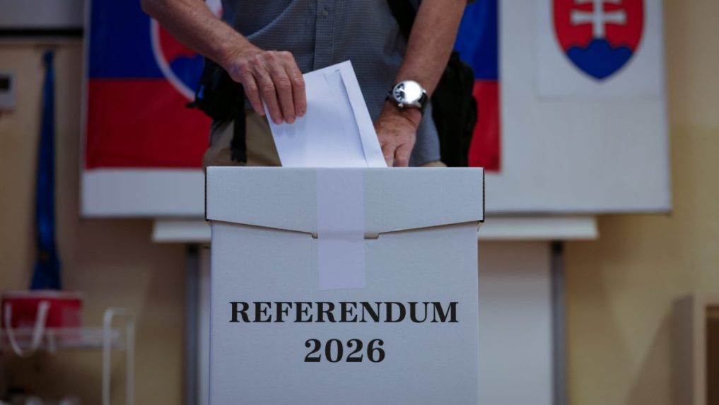 Volič vhadzuje obálku s hlasovacím lístkom do volebnej schránky.
