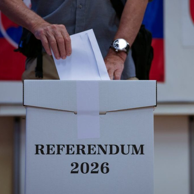 Volič vhadzuje obálku s hlasovacím lístkom do volebnej schránky.