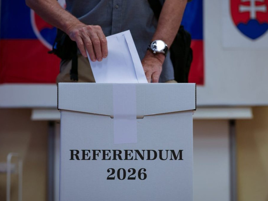 Volič vhadzuje obálku s hlasovacím lístkom do volebnej schránky.