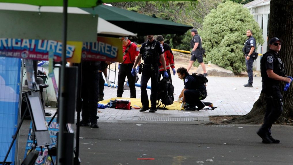 Policajt zakrýva osobu po streľbe počas gastronomického festivalu v Seattli.
