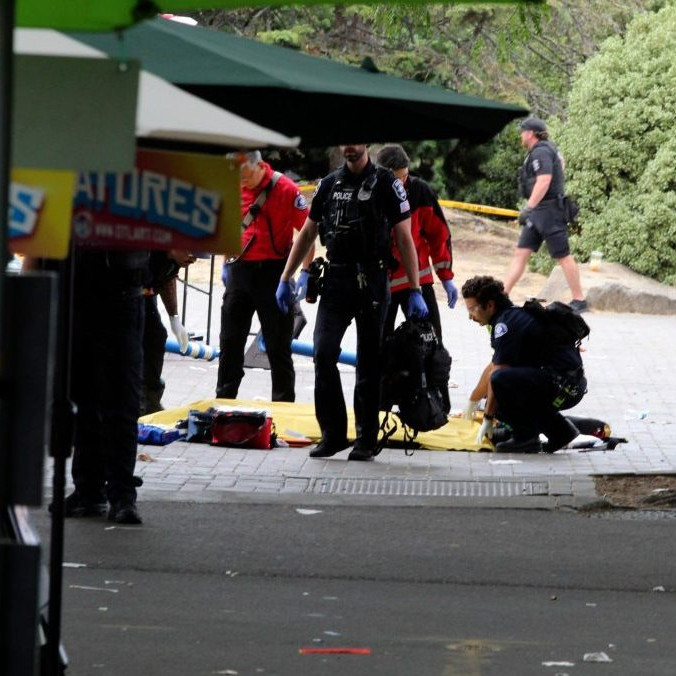 Policajt zakrýva osobu po streľbe počas gastronomického festivalu v Seattli.