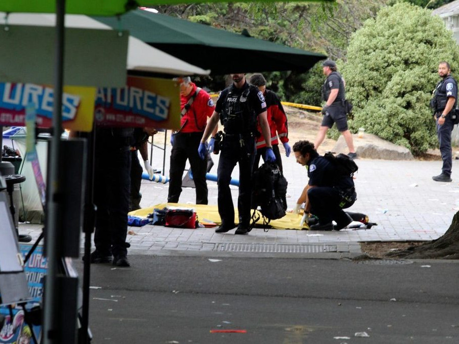 Policajt zakrýva osobu po streľbe počas gastronomického festivalu v Seattli.