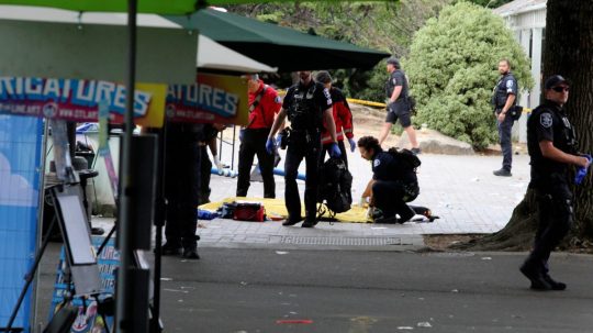 Policajt zakrýva osobu po streľbe počas gastronomického festivalu v Seattli.