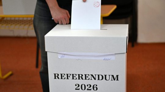 Volič vhadzuje obálku s hlasovacím lístkom do volebnej schránky.