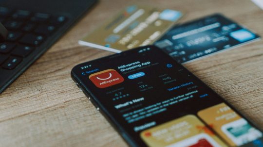 Na snímke platobné karty a telefón s aplikáciou Aliexpress.