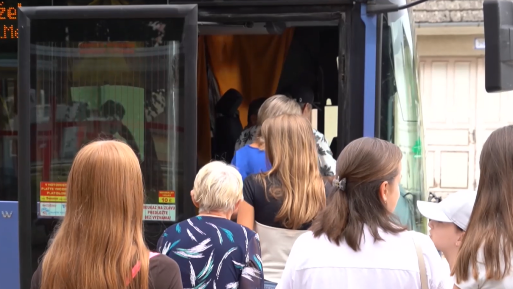 ľudia nastupujú do autobusu