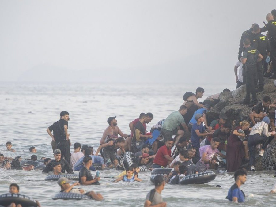 Na snímke migranti prichádzajúci do Ceuty.