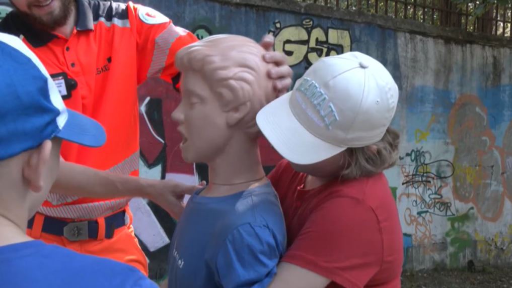 Na snímke záchranár učí dieťa, ako zachrániť niekoho pred dusením.