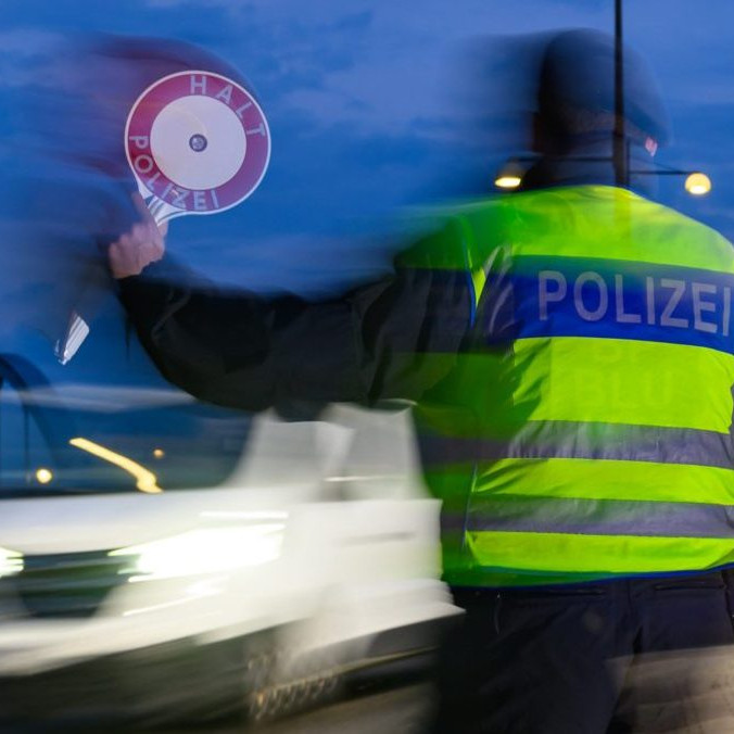 Policajt zastavuje vodiča osobného auta počas kontroly na nemecko-poľských hraniciach.