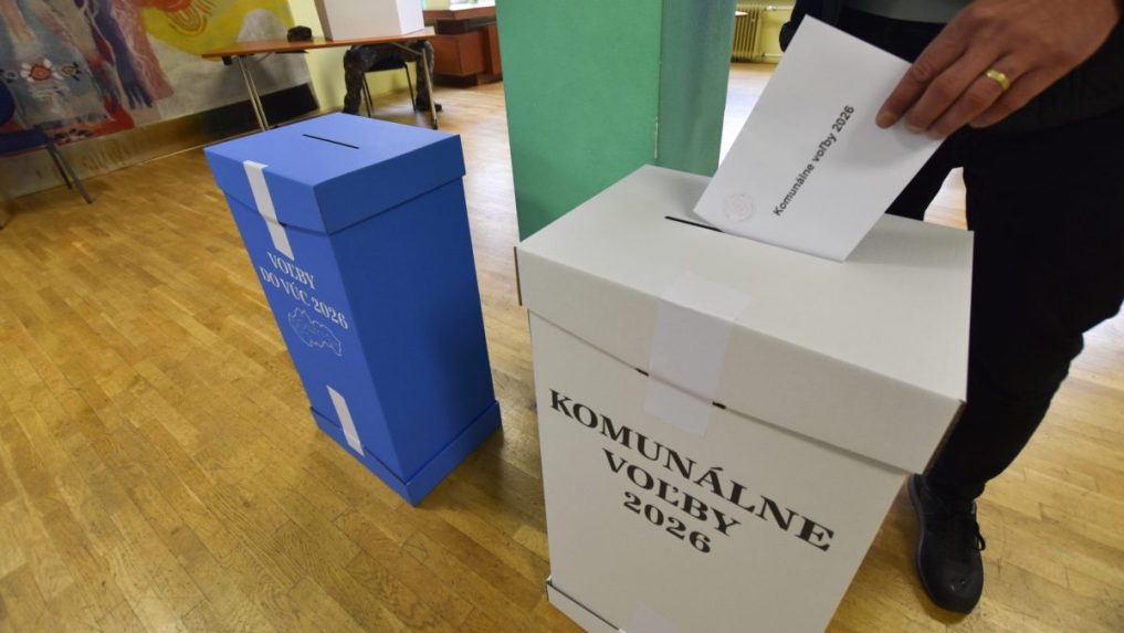 Volič vhadzuje obálku s hlasovacími lístkami do volebnej schránky.