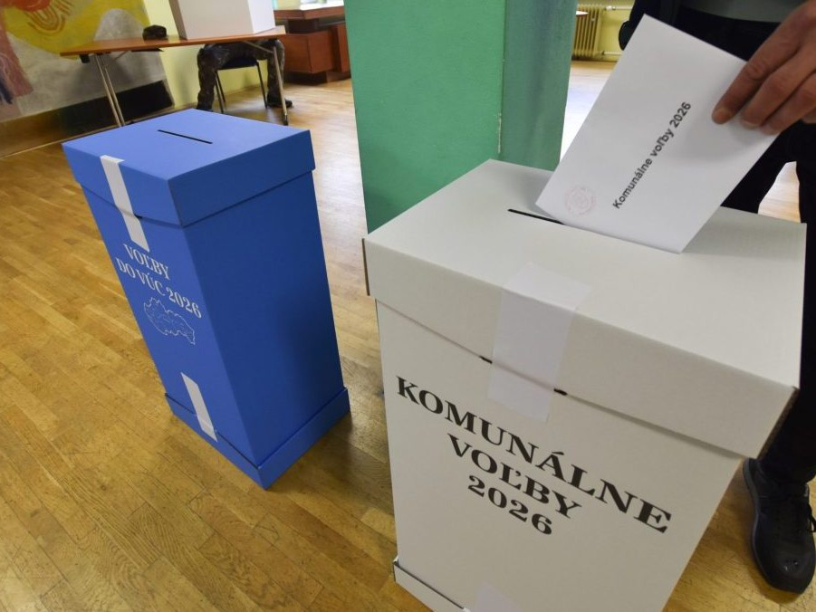 Volič vhadzuje obálku s hlasovacími lístkami do volebnej schránky.
