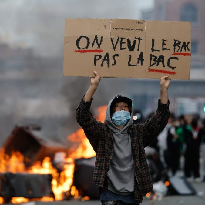 Študent s transparentom na proteste.