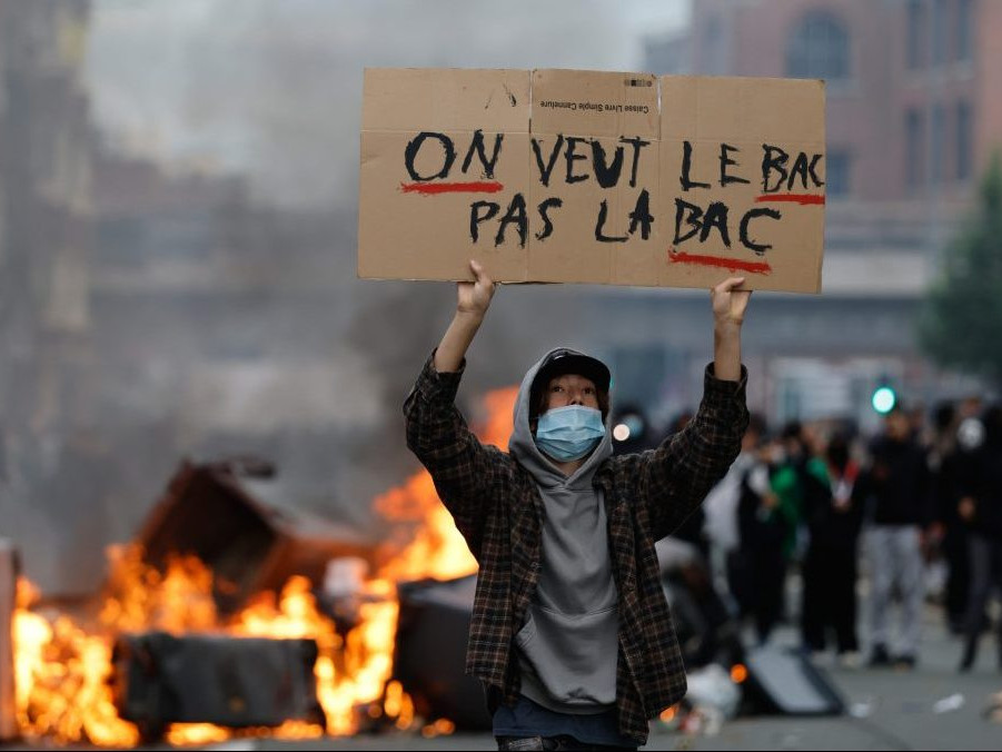 Študent s transparentom na proteste.