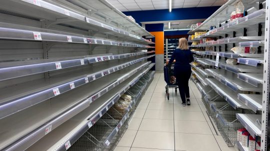 Žena prechádza prázdnou uličkou v talianskom supermarkete.