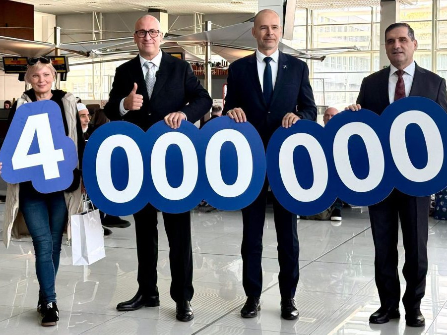 Na snímke cestujúca Petra drží spolu s ministrom dopravy, riaditeľom letiska a tureckým veľvyslancom číslo 4 000 000.