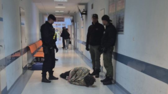Na snímke policajti stoja pri spacifikovanom útočníkovi v bratislavskej nemocnici.