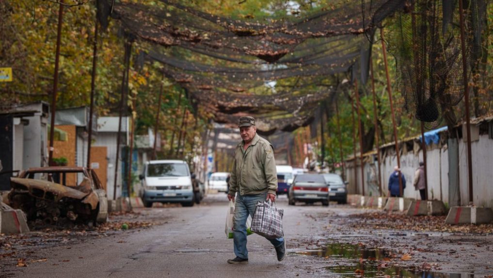 muž kráča po ulici s nákupnými taškami