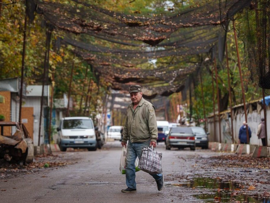 muž kráča po ulici s nákupnými taškami